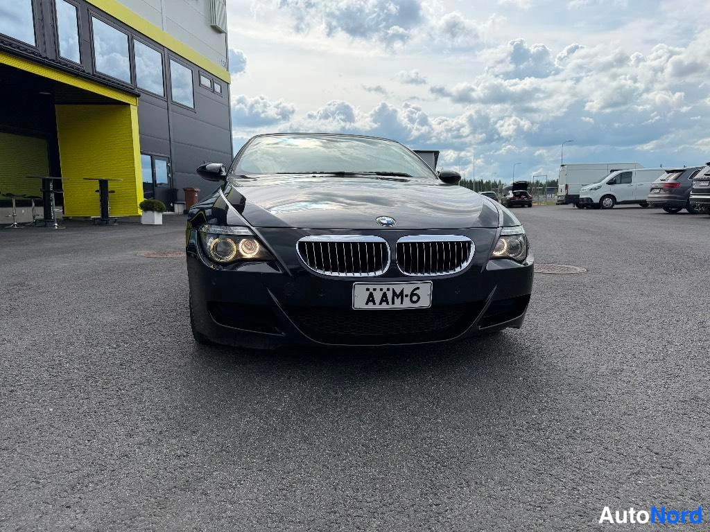 Edestä: Mustan BMW:n keulakuva, rekisteritunnus