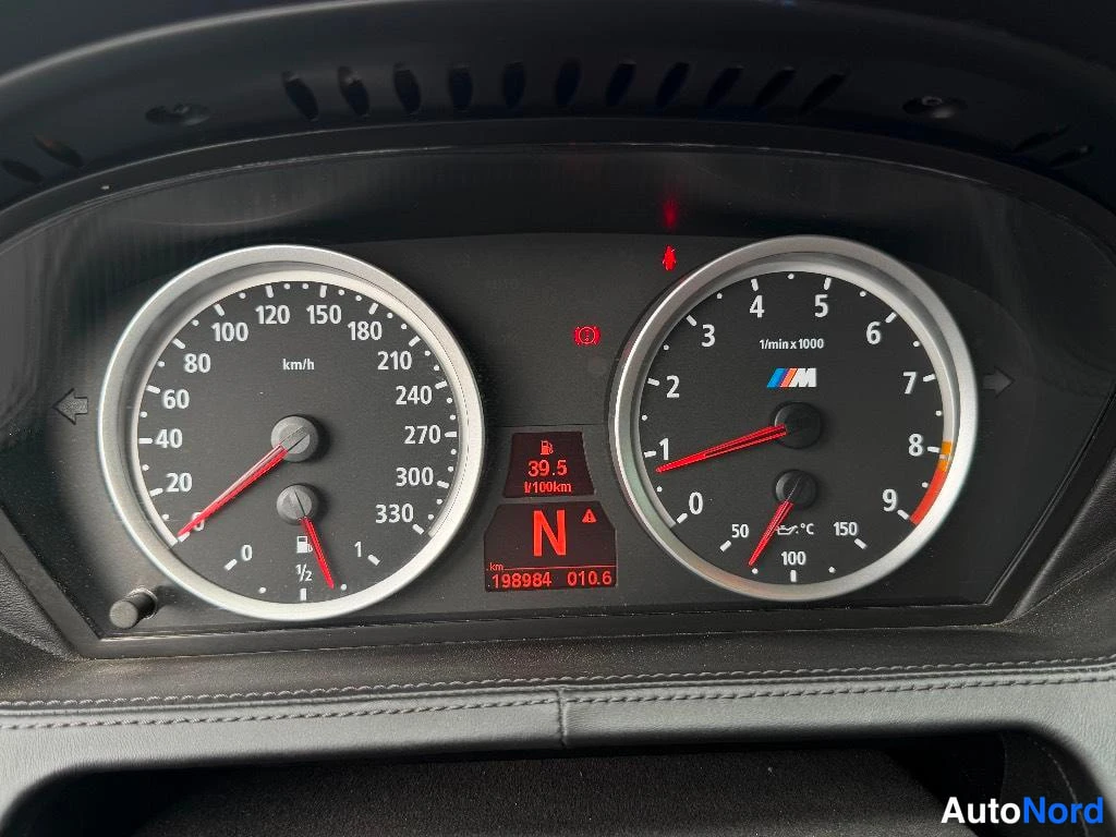 Muu: BMW:n mittaristo: nopeusmittari asteikolla 0–330 km/h, kierroslukumittari 0–9 ja M-merkki, näytössä lukema 198984 km ja vaihde N.