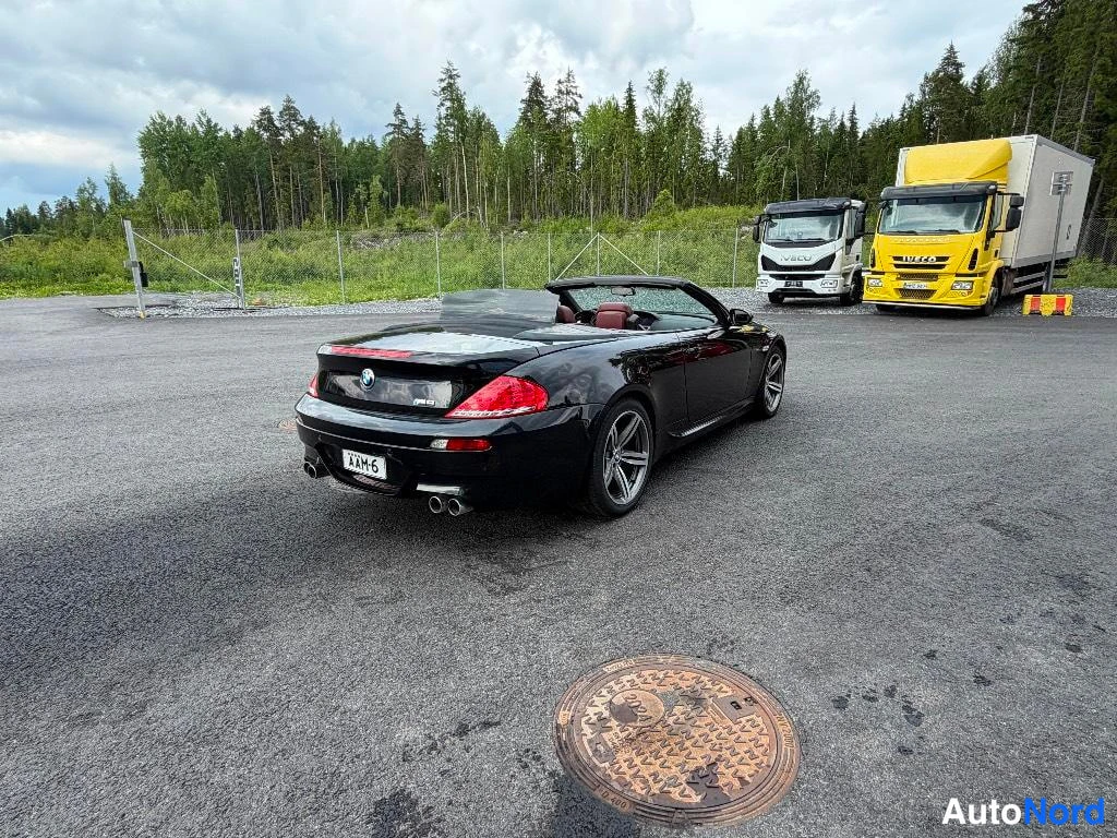 Takaviisto: Musta avoauto takaa kuvattuna, katto auki, neljä pakoputkea ja rekisterikilpi.