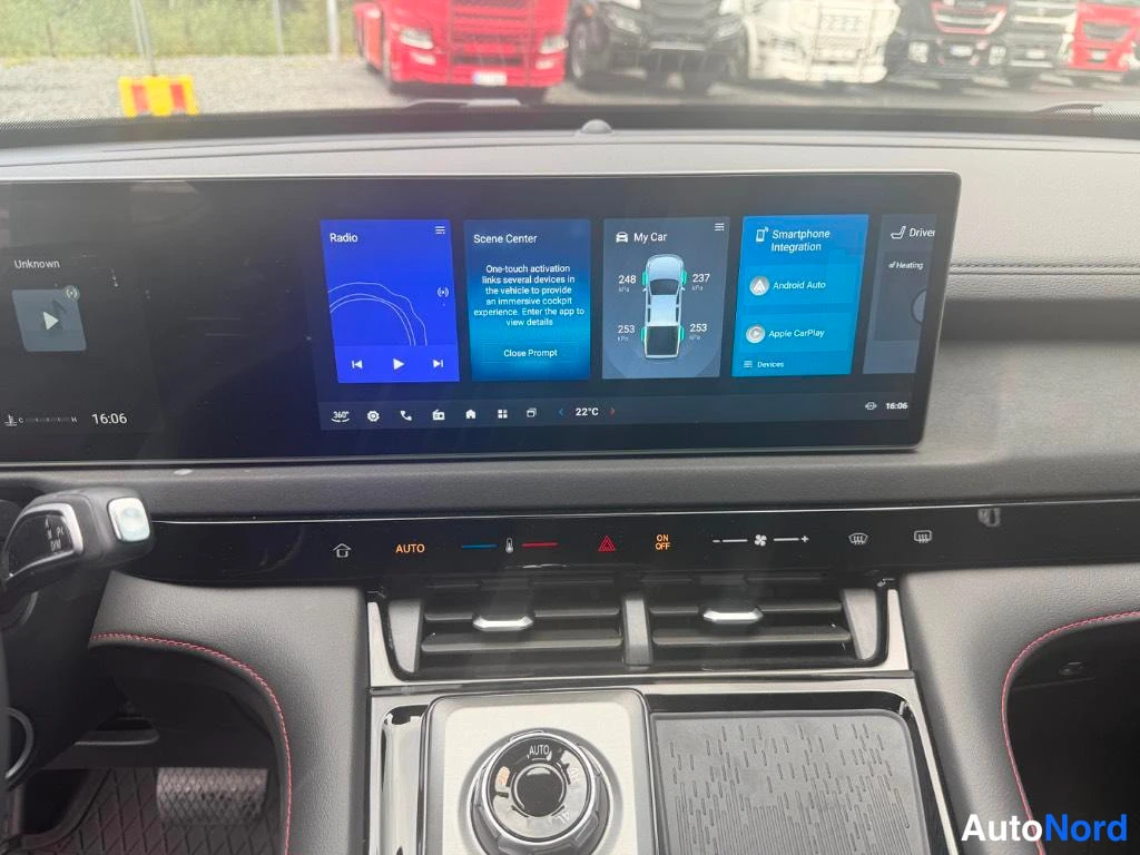 Muu: Kojeen keskellä kosketusnäyttö, jolla näkyy Radio, Scene Center, My Car ja Smartphone Integration -valikot; alla automaattisen ilmastoinnin AUTO-painikkeet ja i