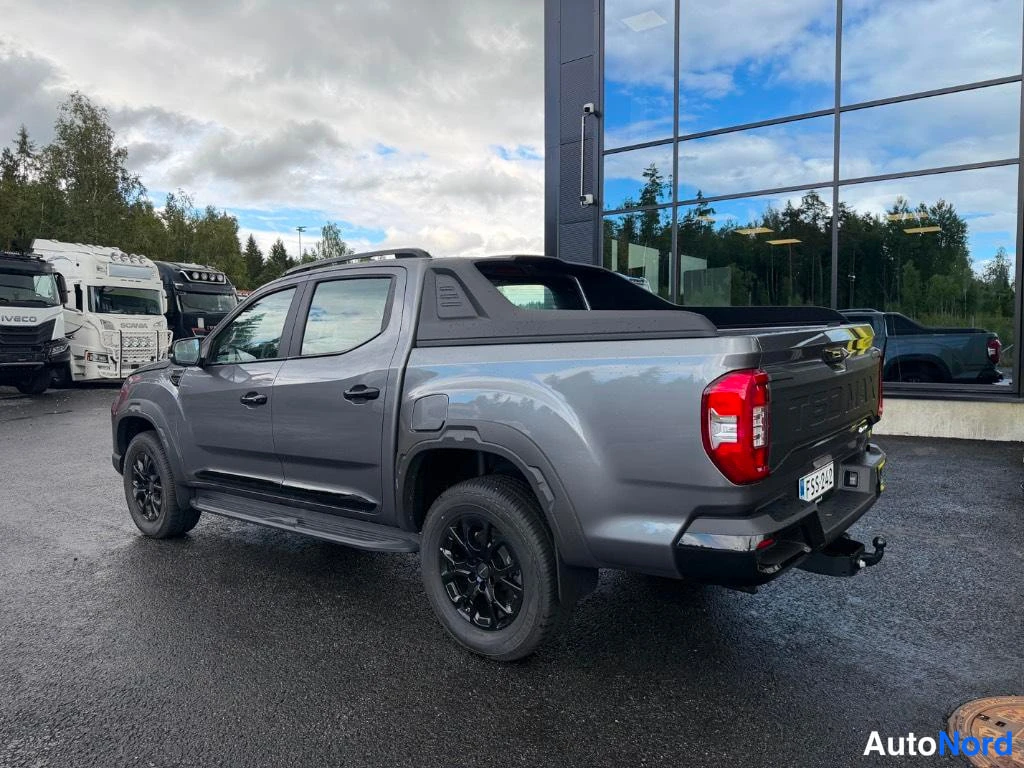 Takaviisto: Harmaan Maxus T60 MAX -pakettiauton rear three quarter (oikea kulma) kuva, näkyy takapää ja oikea sivu, mustat vanteet ja vetokoukku.