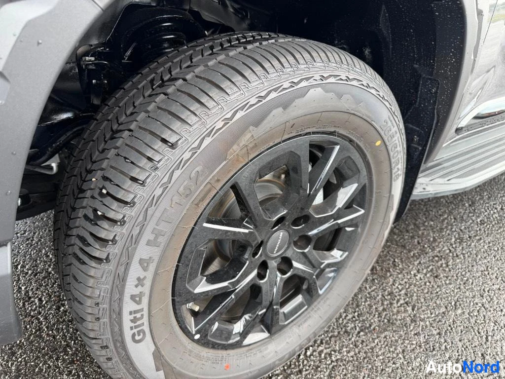 Sivulta: Lähikuva mustasta vanteesta ja renkaasta, kyljessä lukee 'Giti 4x4 HT152'.