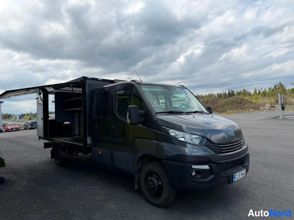 Takaviisto: Front view of the grey Iveco Daily maintenance truck showing headlights and grille.