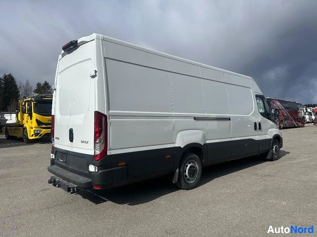 Takaviisto: Valkoinen Iveco Daily -pakettiauto takaa oikealta, korkeat takaovet, takavalot ja musta alakori.