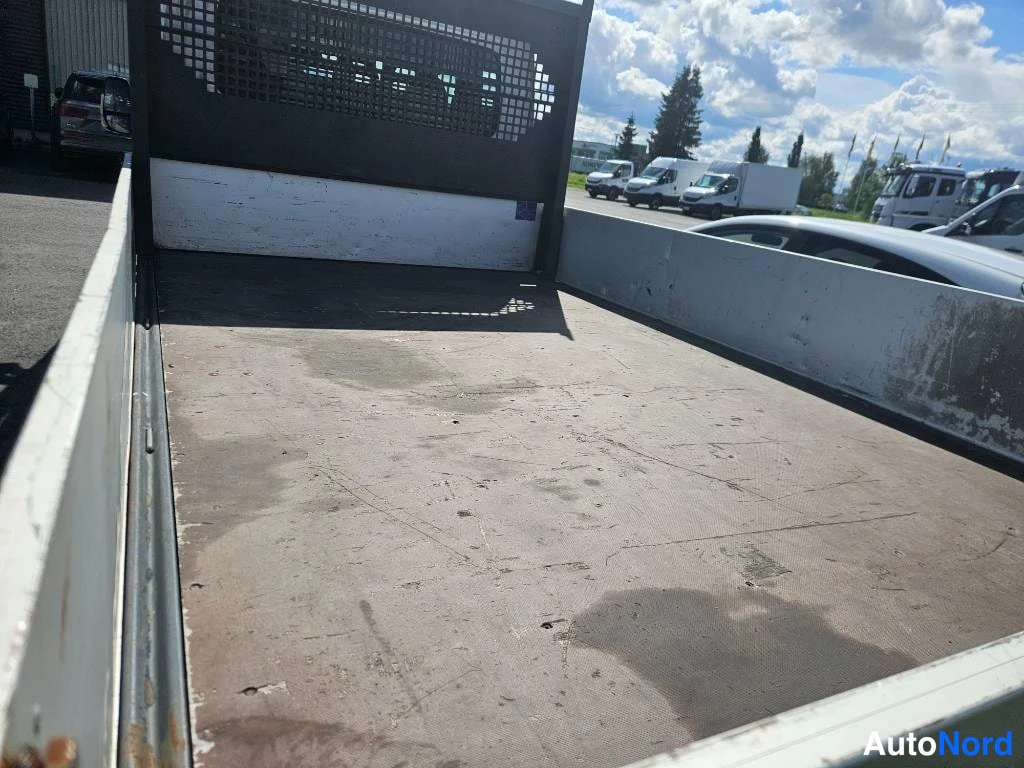Takaa: Tyhjä avolava suojaverkolla takaseinässä, lavan pohja kulunutta.