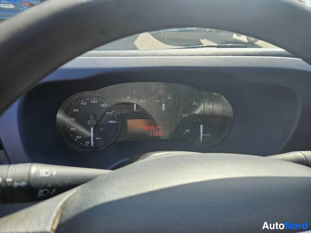 Ohjaamo: Driver's perspective instrument cluster through steering wheel: analog speedometer up to 190 km/h, fuel gauge, temperature gauge, and red LED odometer display r