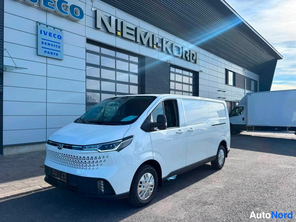 Etuviisto, nokka oikealle: Valkoisen Maxus -pakettiauton etu- ja vasen sivunäkökulma, jossa näkyy etupuskuri, kromattua verkkoinausta sekä kevytmetallivanteet.