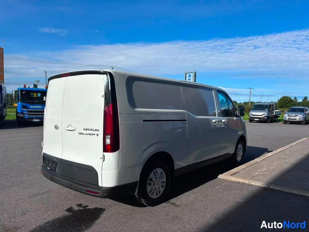 Takaviisto: Valkoisen Maxus Deliver 7 -pakettiauton takasivu; takaluukussa logo ja malli, punaiset takavalo ja metallivanteet.