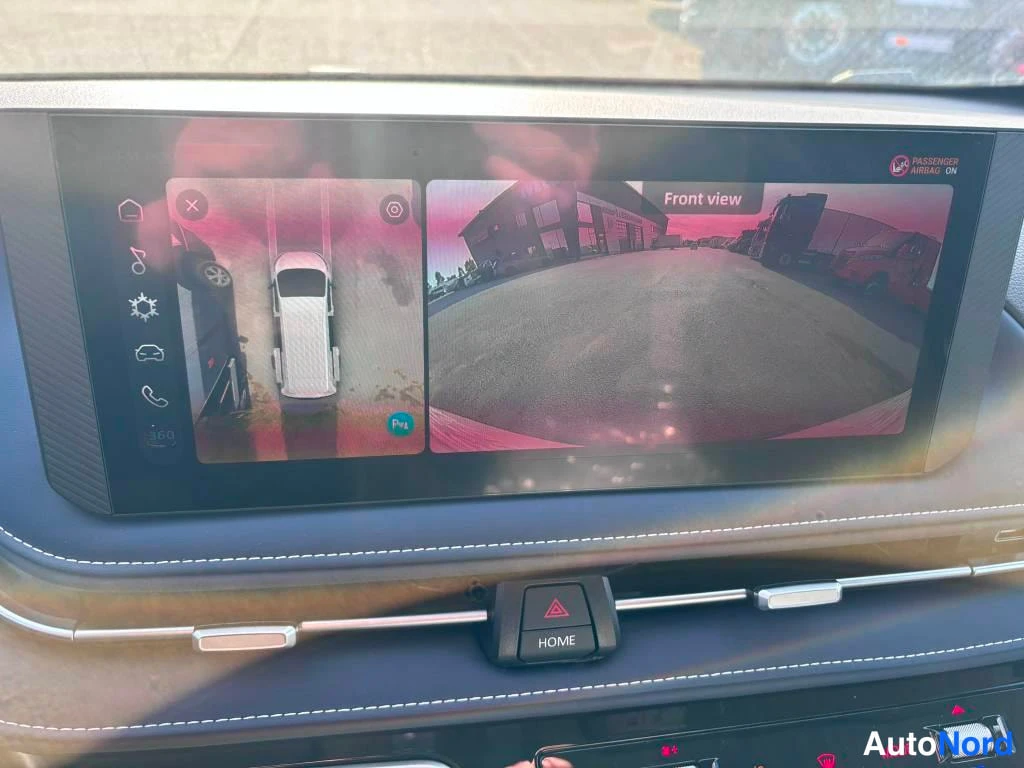 Muu: Kojelaudan infotainment-näyttö, jolla näkyy 360-kameran ylinnäyttö ja Front view -etukamerakuva.