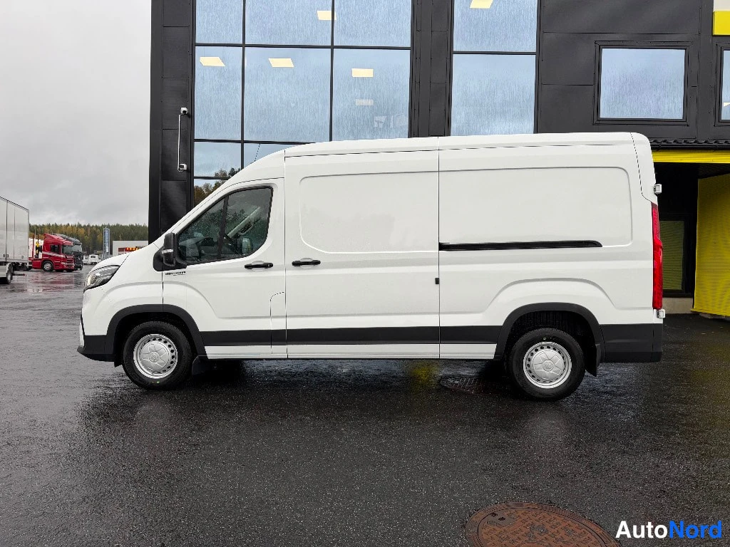 Etuviisto, nokka vasemmalle: Maxus Deliver 9 -pakettiauton kylki ja etuosa kolmasosan kulmasta, valkoinen koripelti ja mustat puskurit