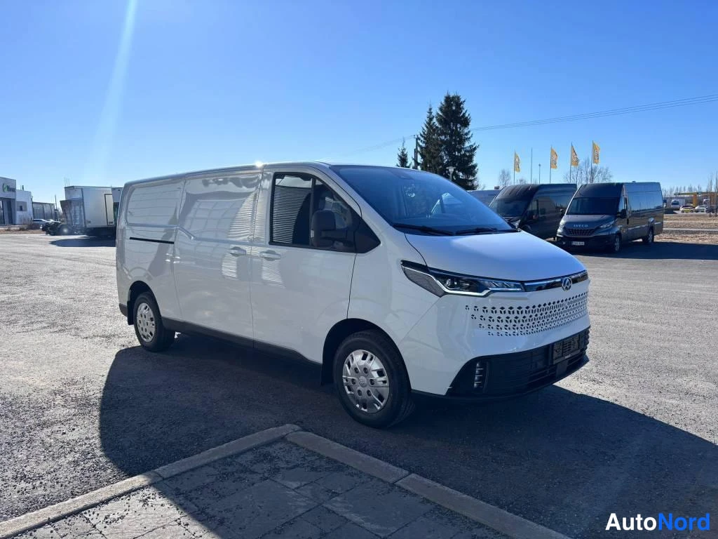 Etuviisto, nokka oikealle: Valkoinen Maxus Deliver 7 -pakettiauto etuviistosta oikealle kuvattuna auringossa parkkipaikalla.