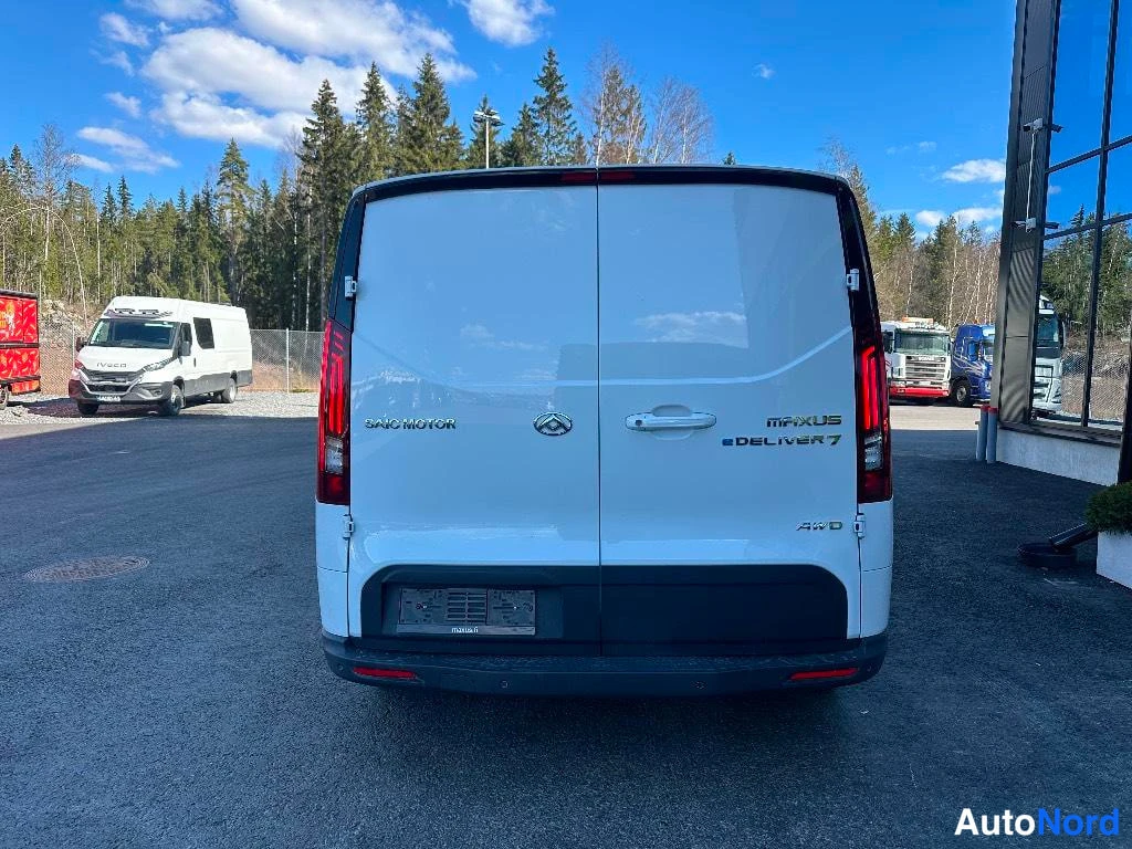 Takaa: Pakettiauton takaosa suoraan takaa: valkoinen koripaneli, pystysuorat takavalot ja kaksiosaiset takarovit. Takaluukussa on tekstit 'SAIC MOTOR', 'MAXUS' ja 'eDE