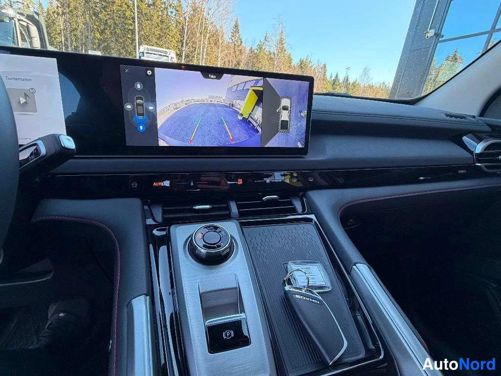 Muu: Kohtele:n näyttö ja keskitaso: laajakulmisen takakameran kuva ja teline-anturi, automaattivalitsin, PARK-nappi ja MAXUS-kaukosäädin