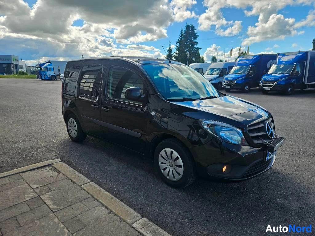 Etuviisto, nokka oikealle: Musta Mercedes-Benz Citan pysäköitynä parkkipaikalle, keulakko kulmassa oikealle.