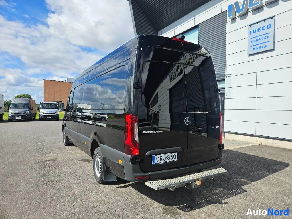 Takaviisto: Mustan Mercedes-Benz Sprinterin takapää, SPRINTER-merkintä ja rekisterikilpi.