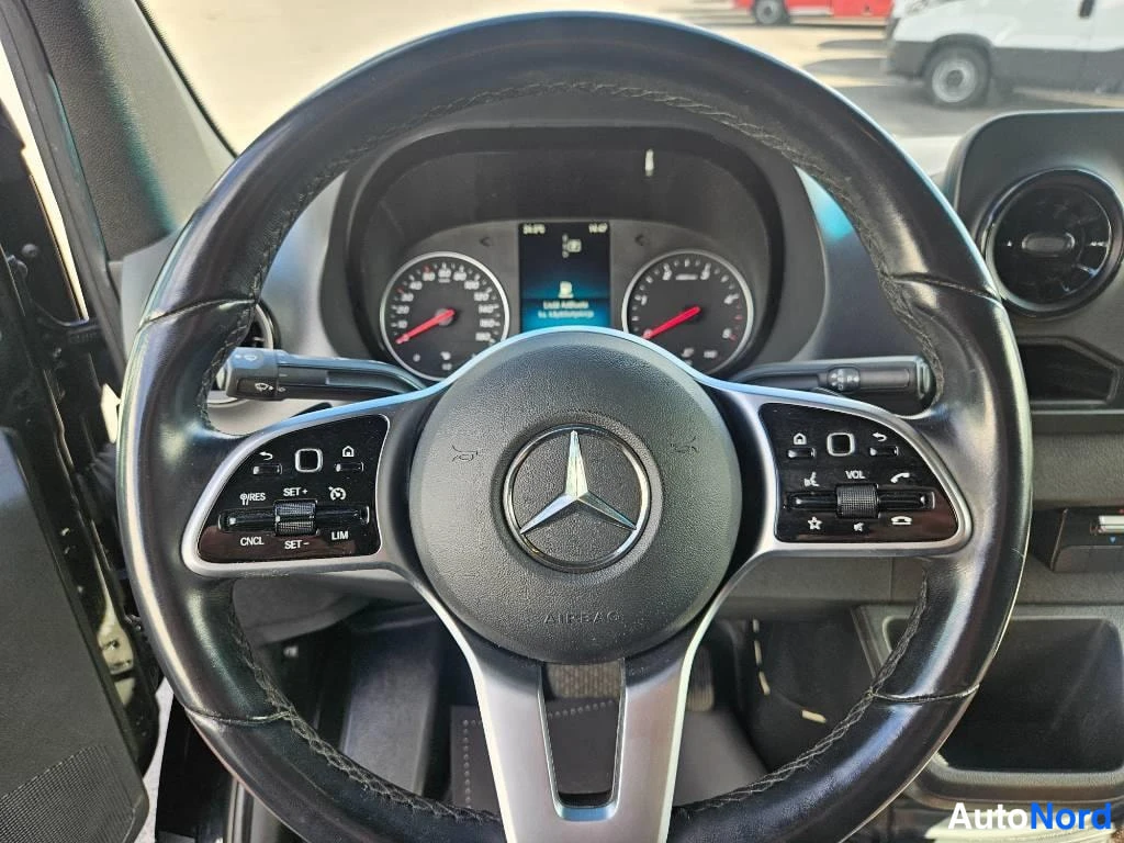 Etuistuimet: Close-up of the Mercedes-Benz steering wheel from the driver's perspective. The wheel is black with silver accents and control buttons on both sides, including