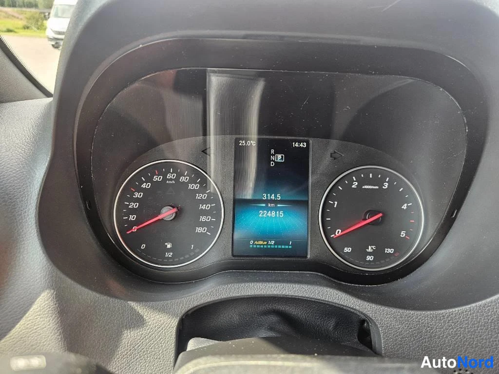 Yksityiskohta: Close-up of the digital instrument cluster behind the steering wheel. The odometer reads 224815 km, and a trip meter shows 314.5 km. The temperature is 25.0°C,