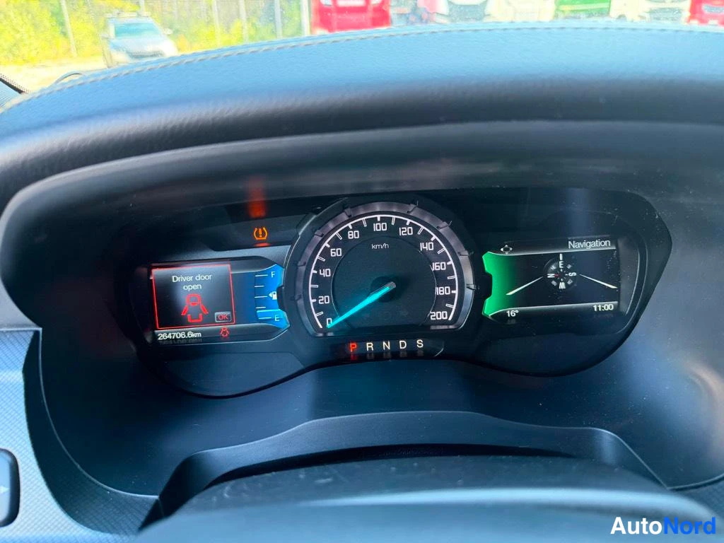 Muu: Mittaristo lähikuvassa: nopeusmittari 0–200 km/h, matkamittari lukee 264706.8 km, varoitusvalo 'Driver door open' ja oikealla navigointikompassinäyttö 16°, kell