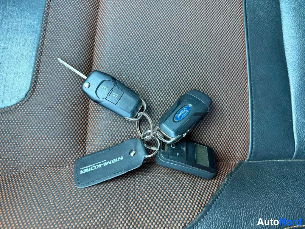 Muu: Avainnippu Ford-avaimilla ja Niem-Korri-avainnauhalla kuvattuna verhoiltua istuinta vasten