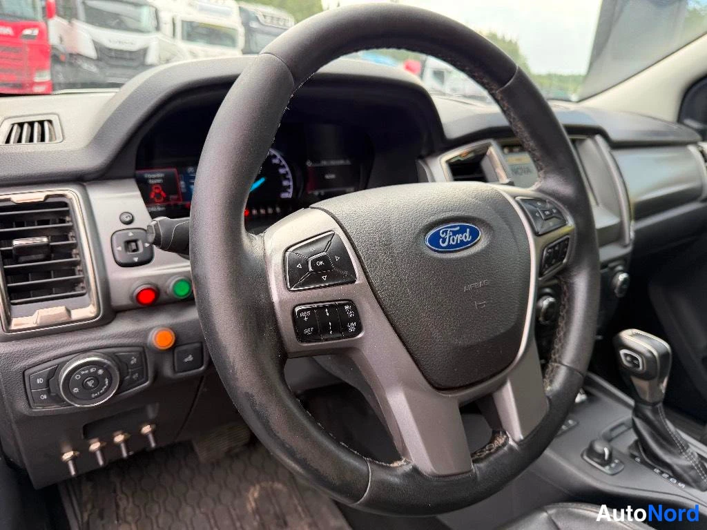 Muu: Lähikuva Ford-ohjauspyörästä ja kojelaudasta, hälytyskytkimillä vasemmalla.