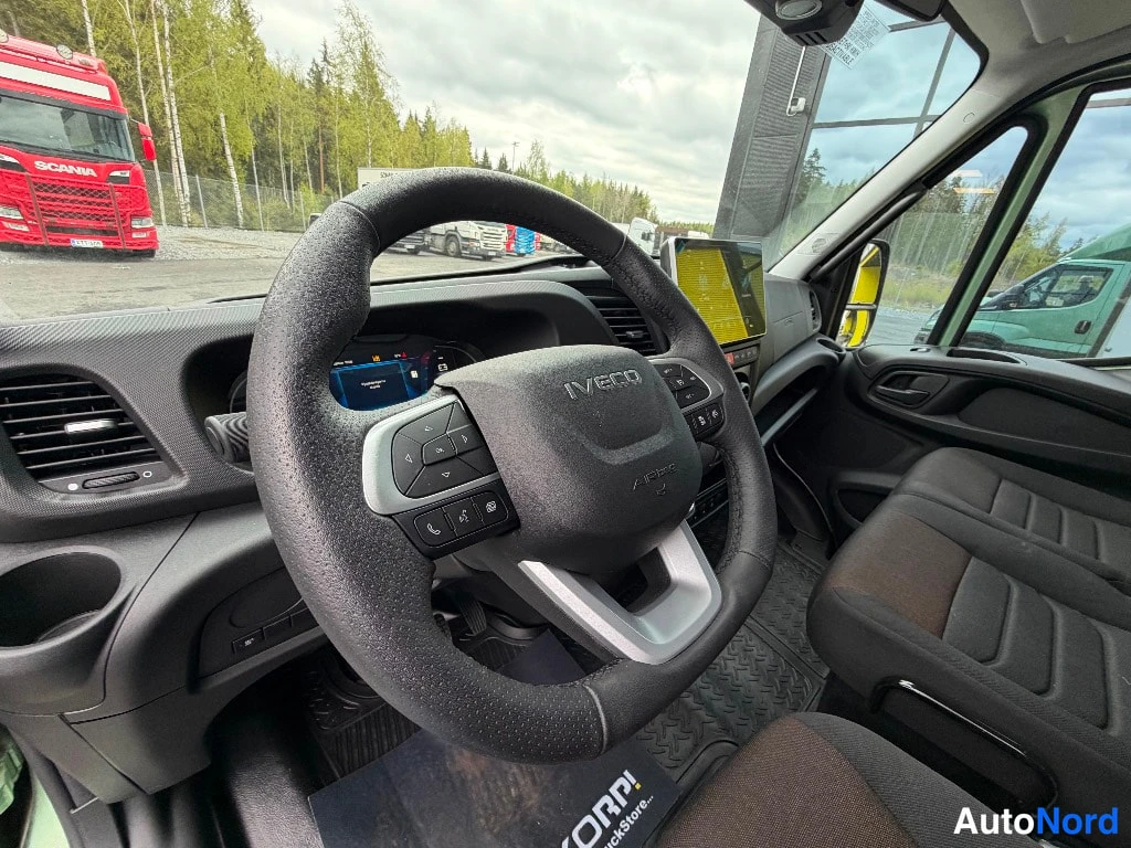 Sivulta: Lähikuva ohjauspyörästä, jonka keskiosassa lukee IVECO ja Aipso, sekä osittain näkyvästä kojelaudasta ja matkustajan istuimesta.