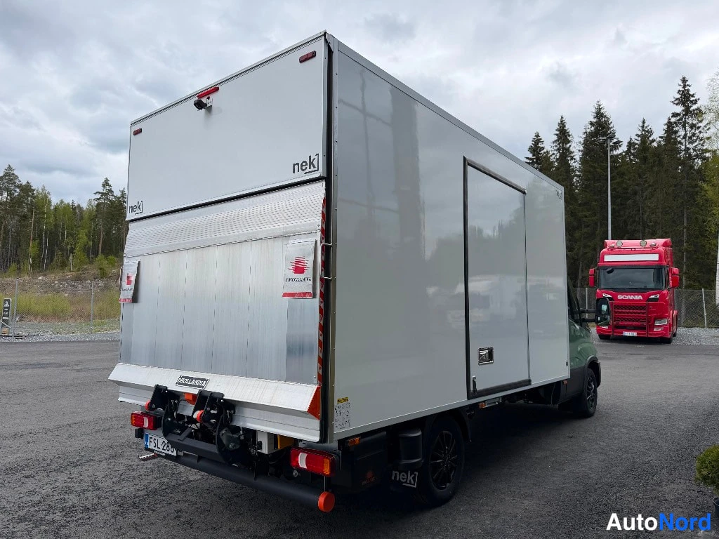 Takaviisto: Paku takaviistosta: valkoisen nek-korin perällä Bär Cargolift -nostolauta taitettuna ylös, korin takaovi ja kylkiovi auki-asennossa, kamerajalusta korin katolla