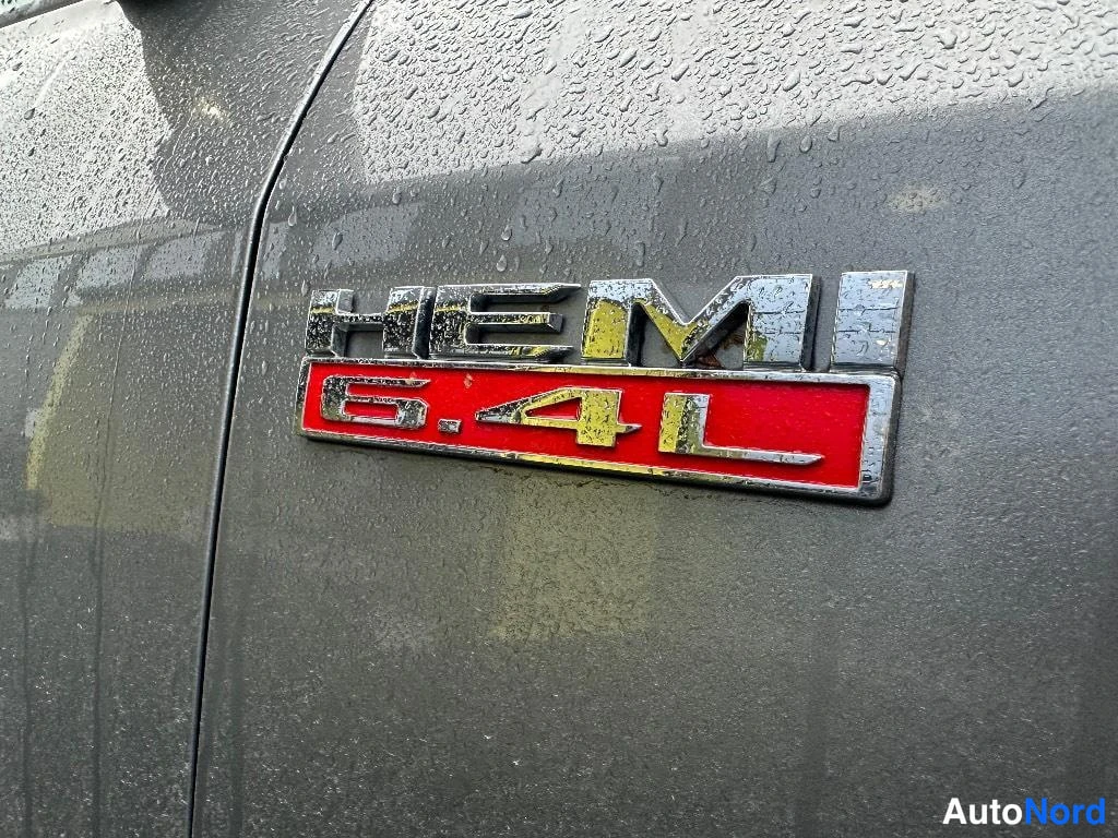 Sivulta: Sivukolmion tarkan lähikuvan HEMI 6.4L -merkinnästä sateessa märällä harmaalla peltipinnalla