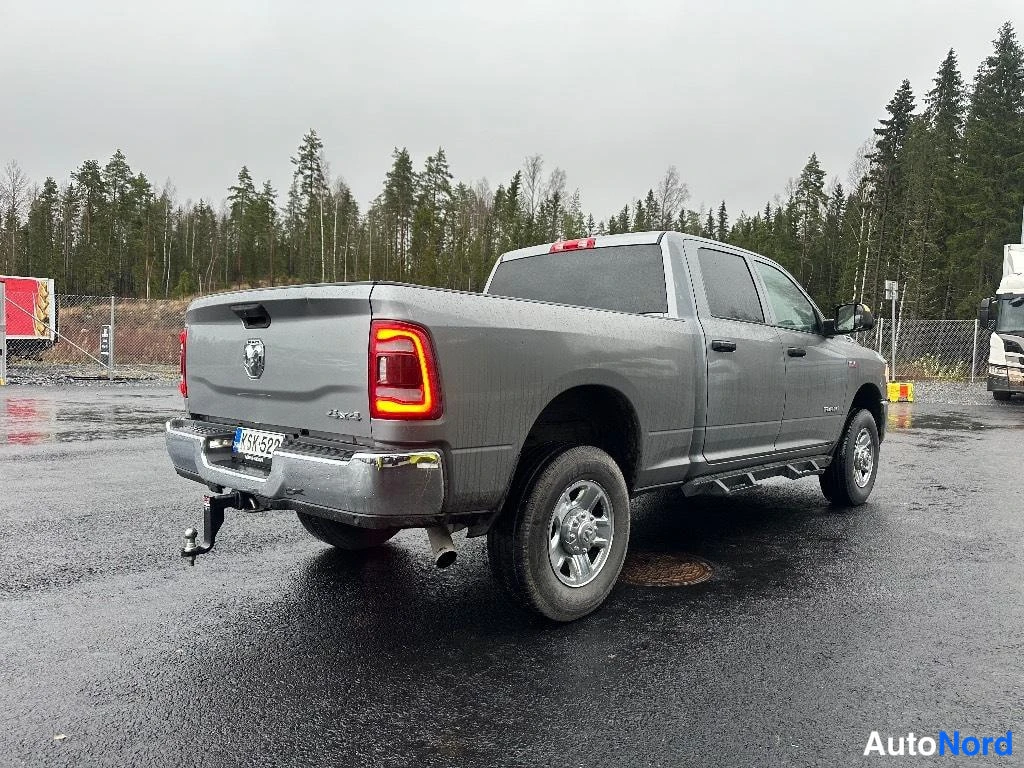 Takaviisto: RAM 2500 -nokka-auton takakulma, avolava, takavalot päällä ja vetokoukku näkyvissä.