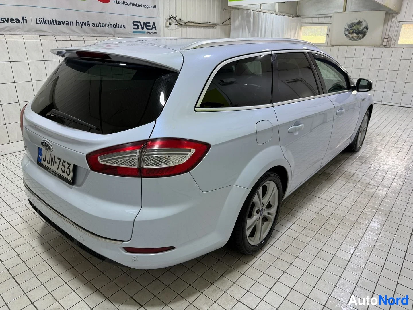 Takaviisto: Ford Mondeo -farmari takaa viistosti oikealta, valkoinen korimuvi.