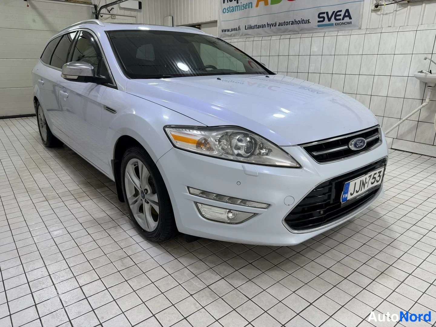 Etuviisto, nokka oikealle: Ford Mondeo Farmari etuviistosta oikealta kuvattuna, valkoinen kori, rekisteritunnus.