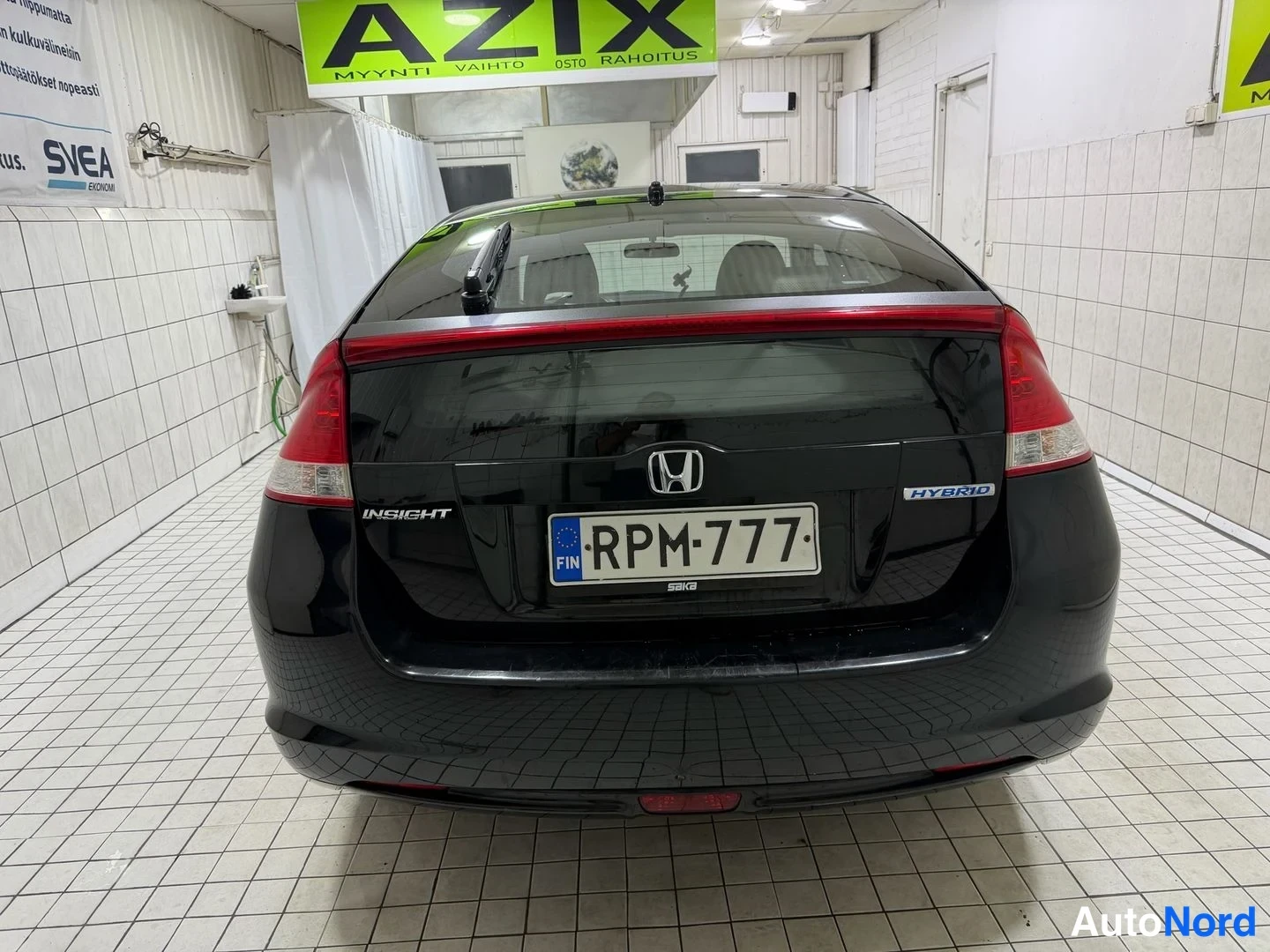 Takaa: Mustan Honda Insightin takaosa suoraan takaa, HYBRID-merkki ja rekisterikilpi.