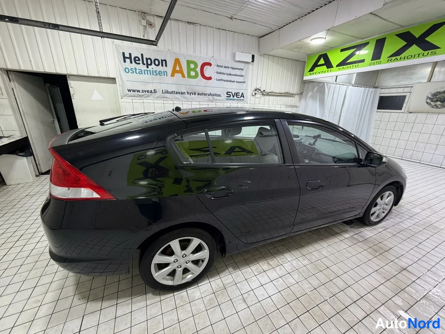 Takaviisto: Honda Insight -viistoperäisen takapää ja vasen sivu kulmasta, tummat ovipanelit ja kevytmetallivanteet.