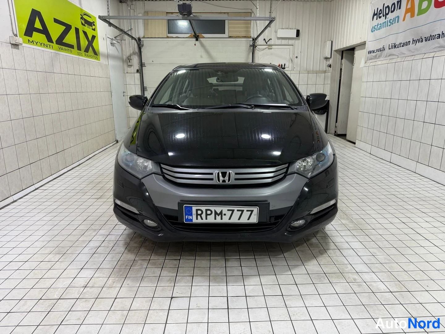 Edestä: Honda Insightin keula suoraan edestä, etusäleikkö ja ajovalot, rekisterikilpi.