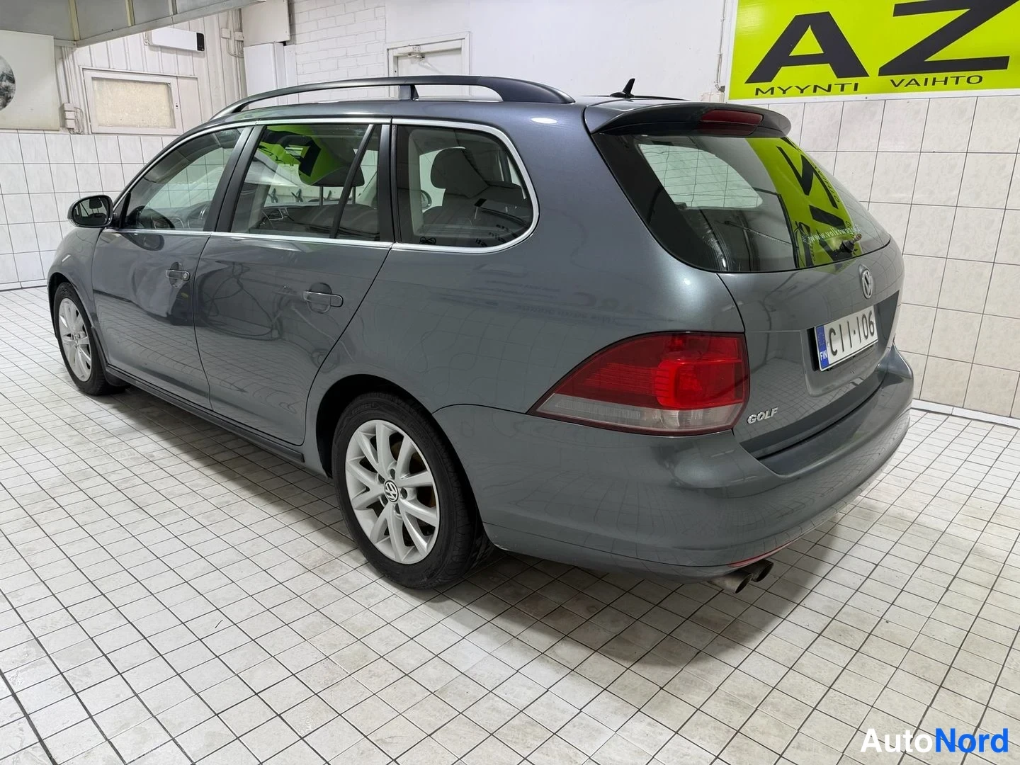 Takaviisto: Harmaan Volkswagen Golf Variant -farmingon takakulma vasemmalta, takavalot ja rekisteritunnus näkyvissä.