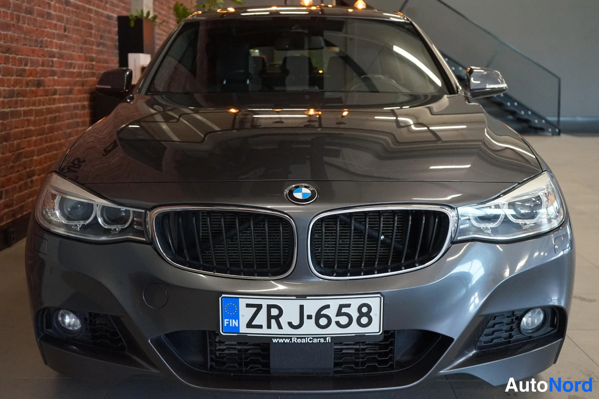 Edestä: Auton etupää edestäpäin: BMW-merkki, etugrilli, sumvalot ja rekisterikilpi.