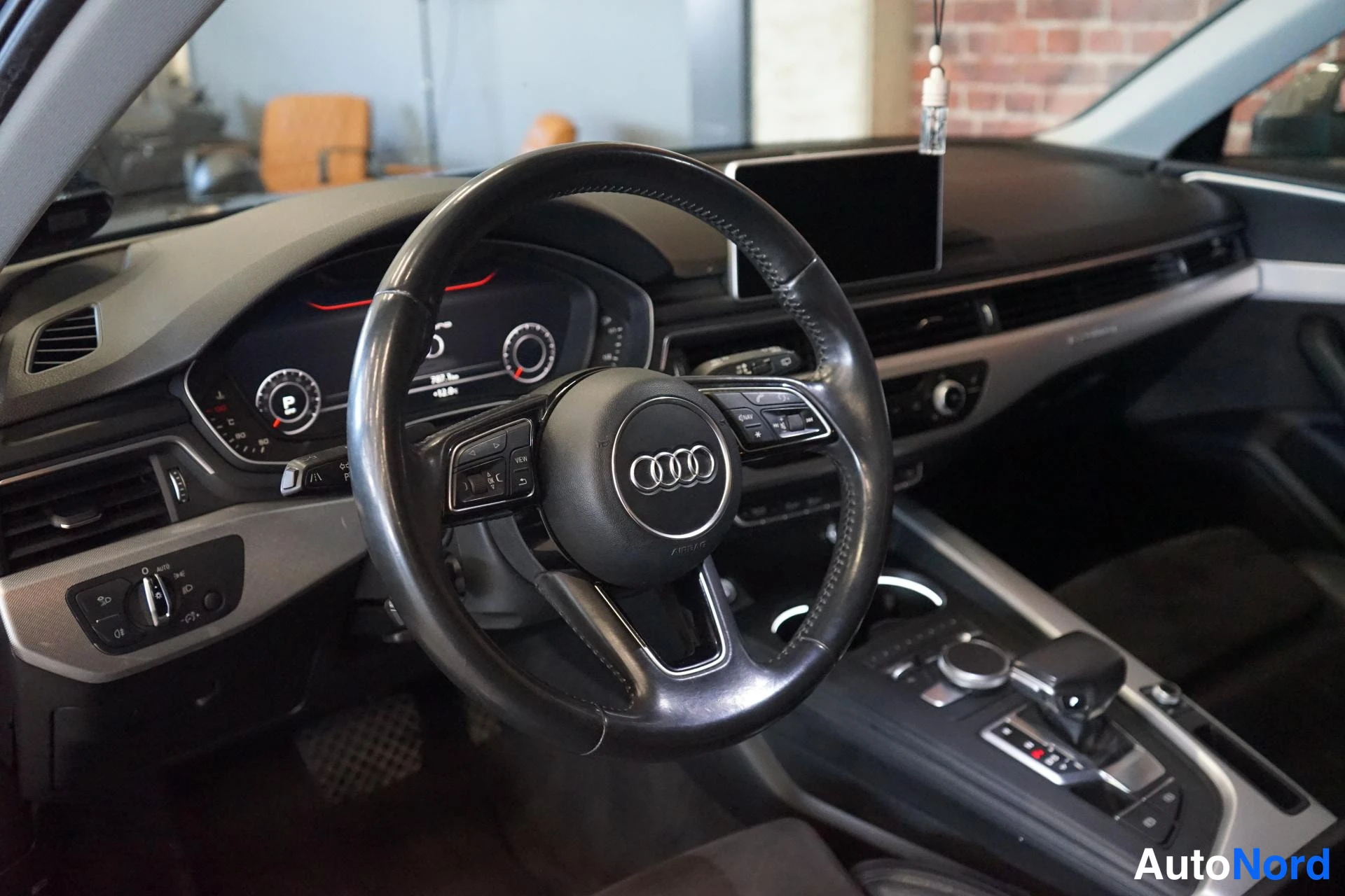 Muu: Ohjaamon näkymä: Audi-ohjauspyörä, digitaalinen mittaristo ja keskikonsoli.