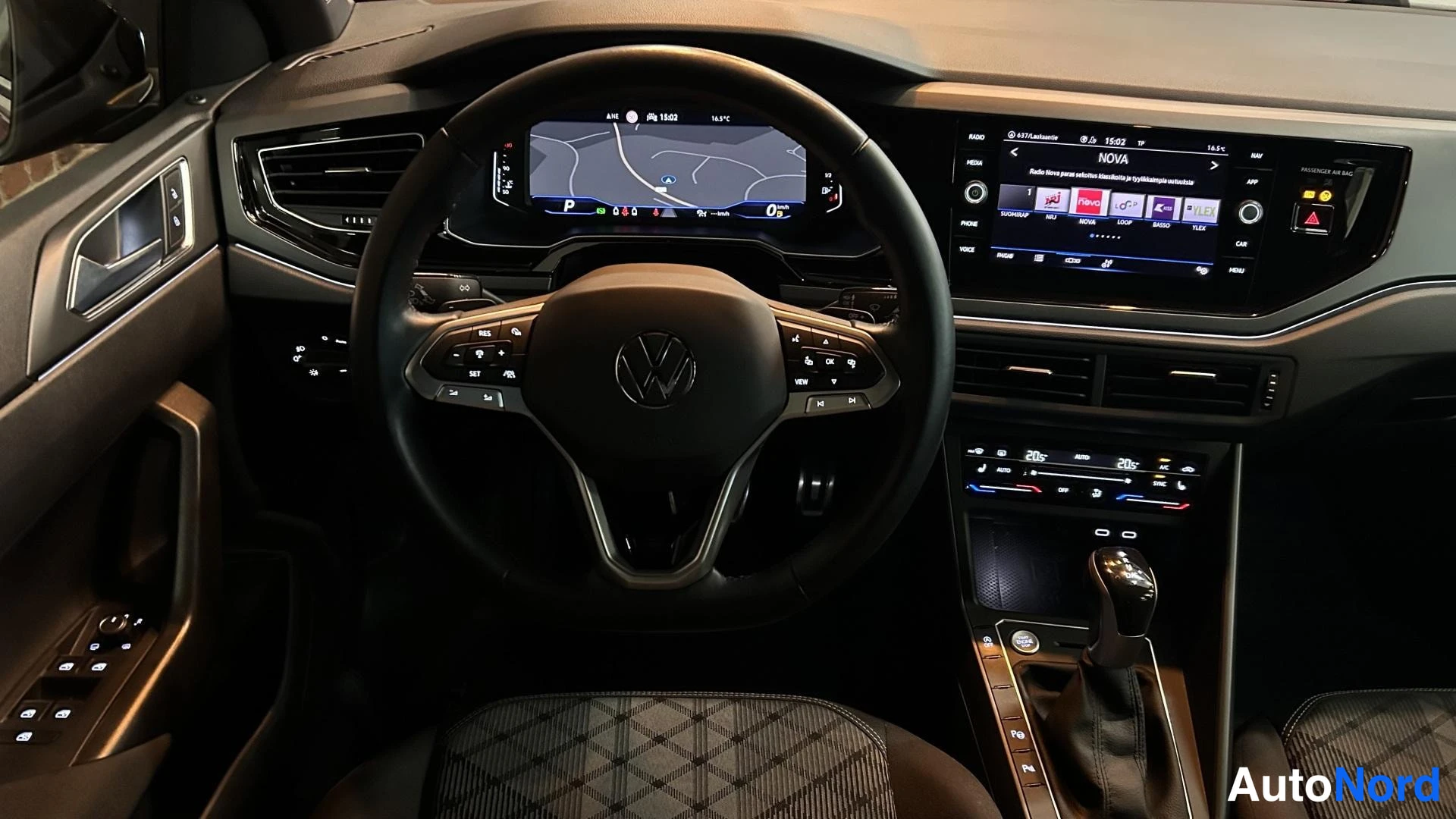 Muu: Kuljettajan näkymä kojelautaan: Audi-ohjauspyörä, kartanäyttö mittaristossa, keskinäytössä mediavalikko ja automaattivaihteiston valitsin.