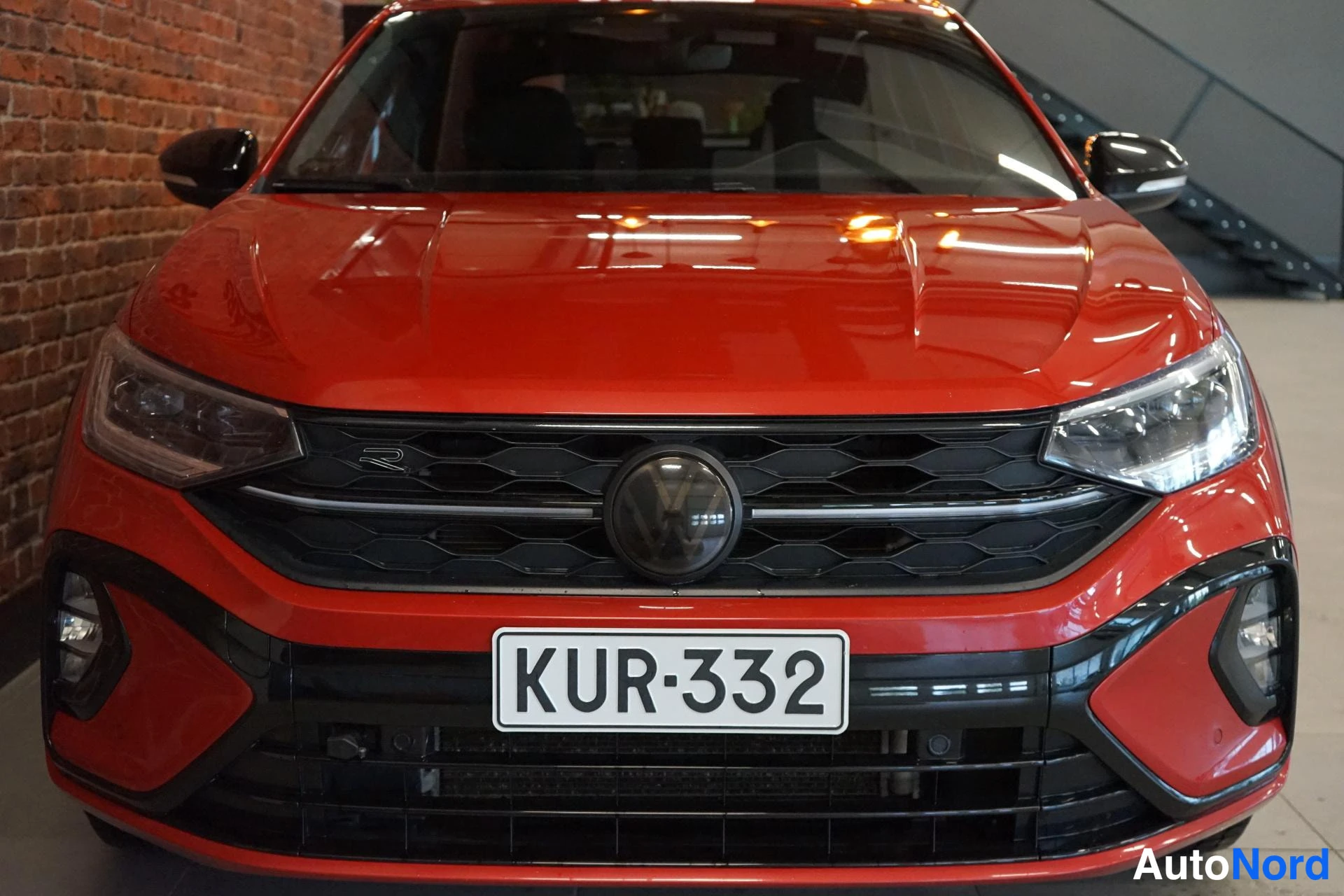 Edestä: Punaisen Volkswagenin etupää suoraan edestä, musta etusäleikkö ja -kilpi.