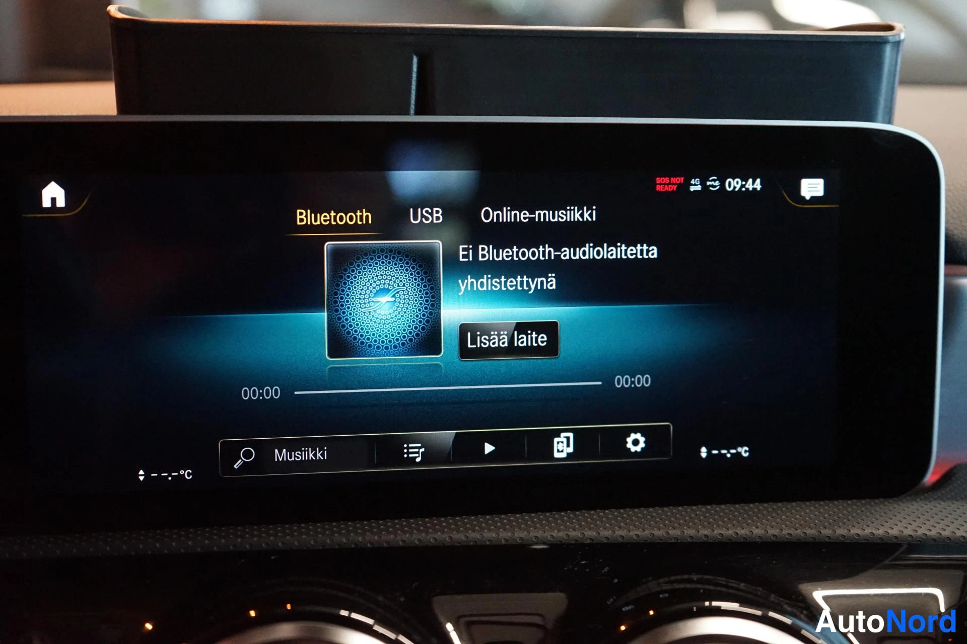 Muu: Riippuva infotainment-näyttö, jossa musiikkivalikko: Bluetooth, USB ja Online-musiikki, ja teksti 'Ei Bluetooth-audiolaitetta yhdistettyä'.
