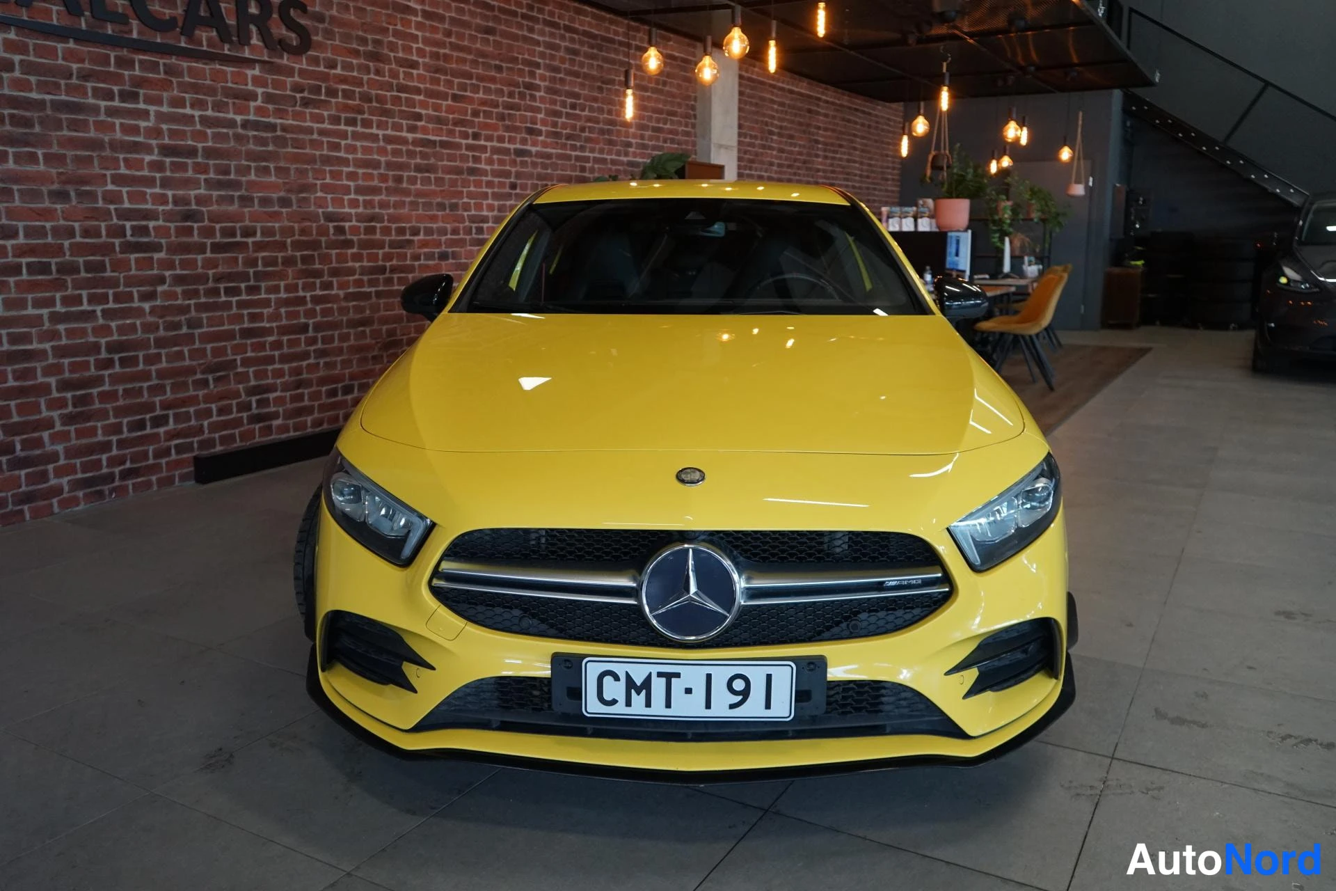 Edestä: Keltainen Mercedes-Benz A 35 AMG edestä, keulakuva näyttää etusäleikön, Mercedes-tähden ja rekisterin.