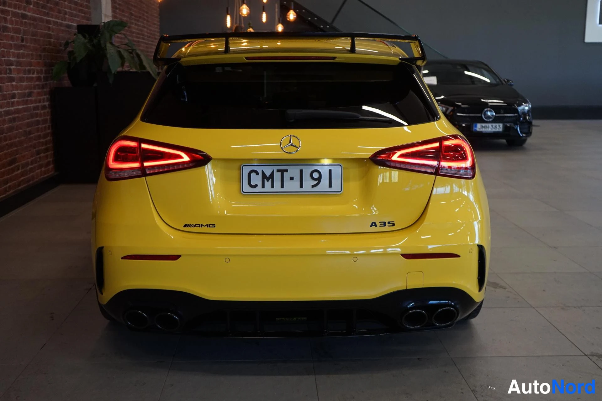 Takaa: Keltaisen Mercedes-Benz A 35:n takapää, AMG- ja A35-merkit sekä kaksinkertaiset pakoputket näkyvät, rekisteri.