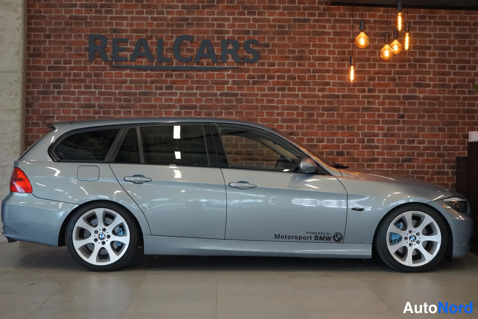 Sivulta: BMW 325 -farmari sivulta oikealta, hopeanharmaa.