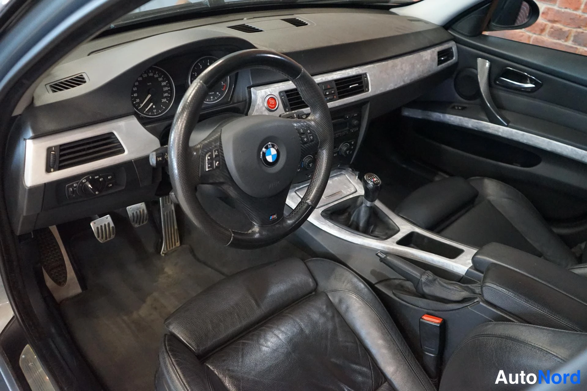 Muu: BMW:n ohjaamo vasemmalta: musta nahkainen urheiluohjaus, manuaalivaihteisto, korimetalistit ja kaksi istuinta.