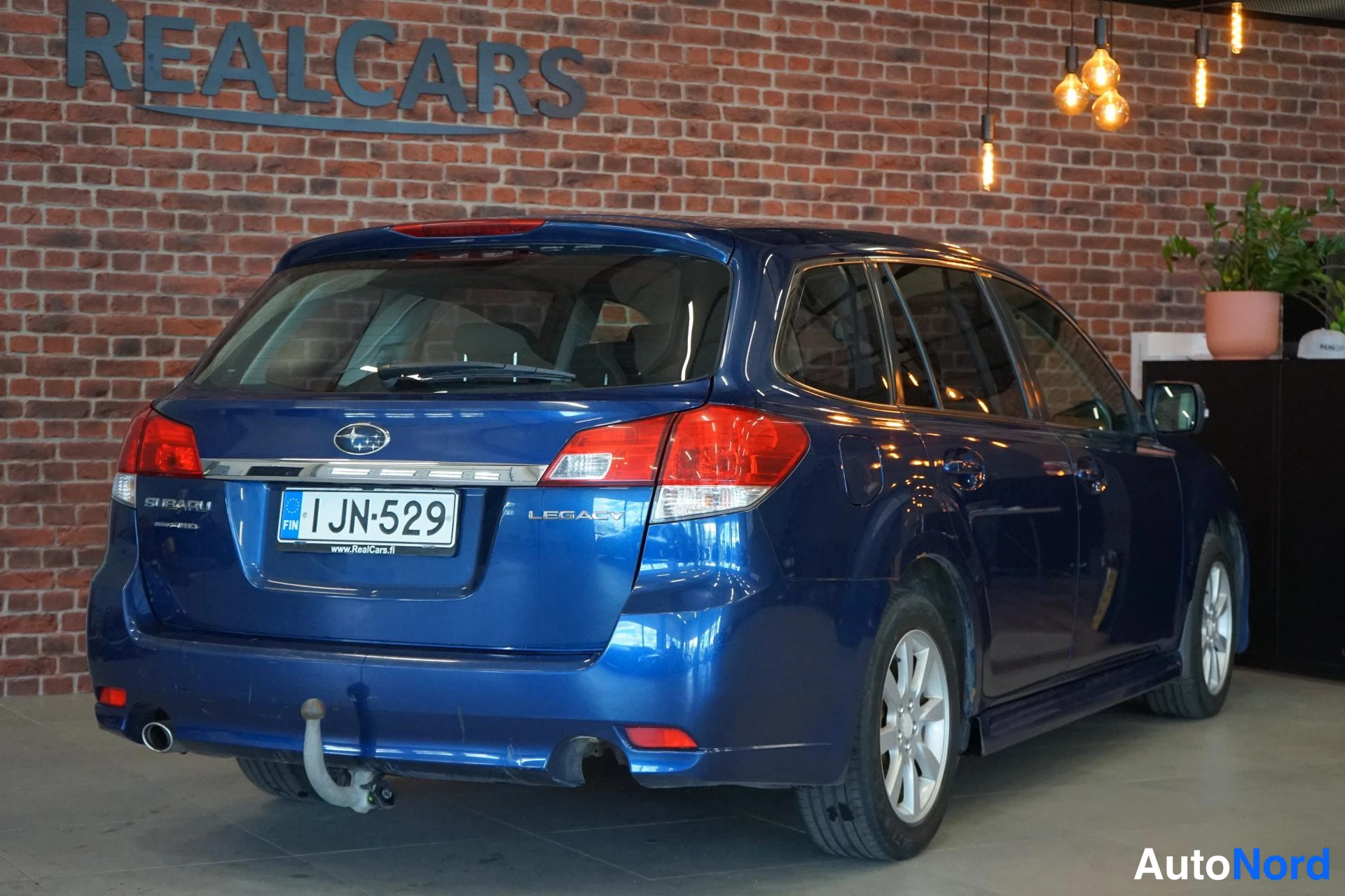Takaviisto: Sininen farmariauto takaviistosta oikealta nähtynä, takapansi ja kylki näkyvissä, kytkinkoukku takapuskissa.