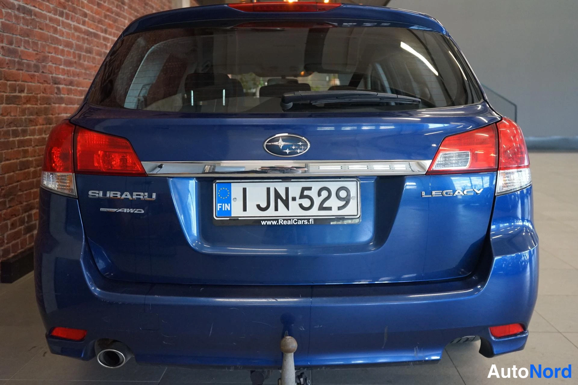 Takaa: Subaru Legacy -farmarin takapää suoraan takaa kuvattuna, rekisteritunnus I JN-529.