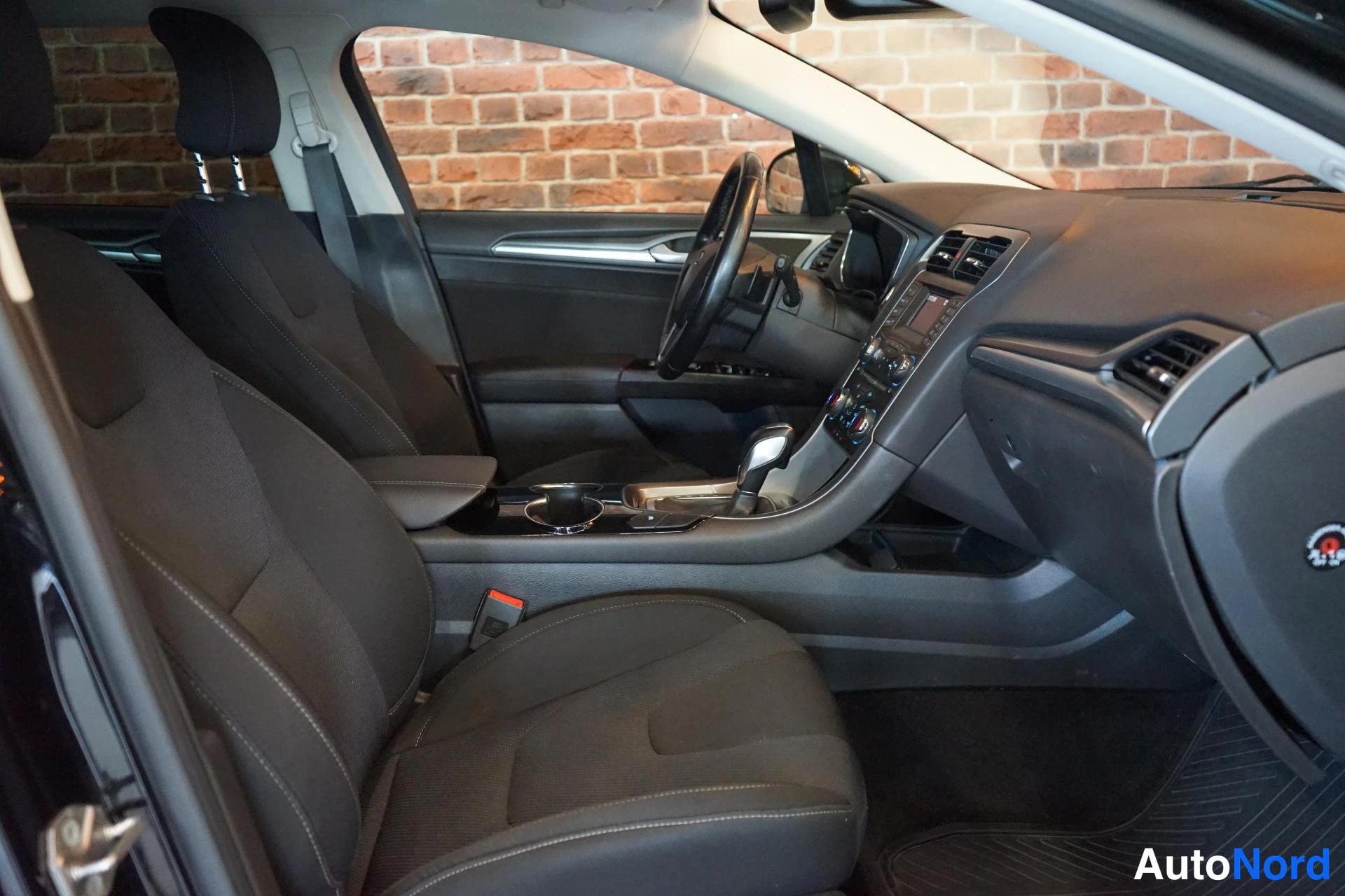 Etuviisto: Ford Mondeo - matkustamon yleiskuva etuistuimista ja kojelaudasta, tumma kankaverhoilu ja keskikonsoli.
