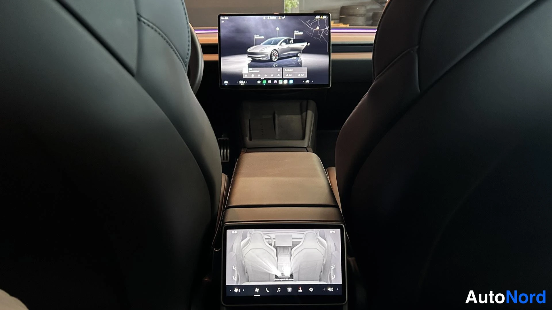 Muu: Tesla Model 3:n sisätilat takaapäin: etuistuinten välissä keskikäyttöliittymä ja takaistuville matkustajille oma pieni ruutu.