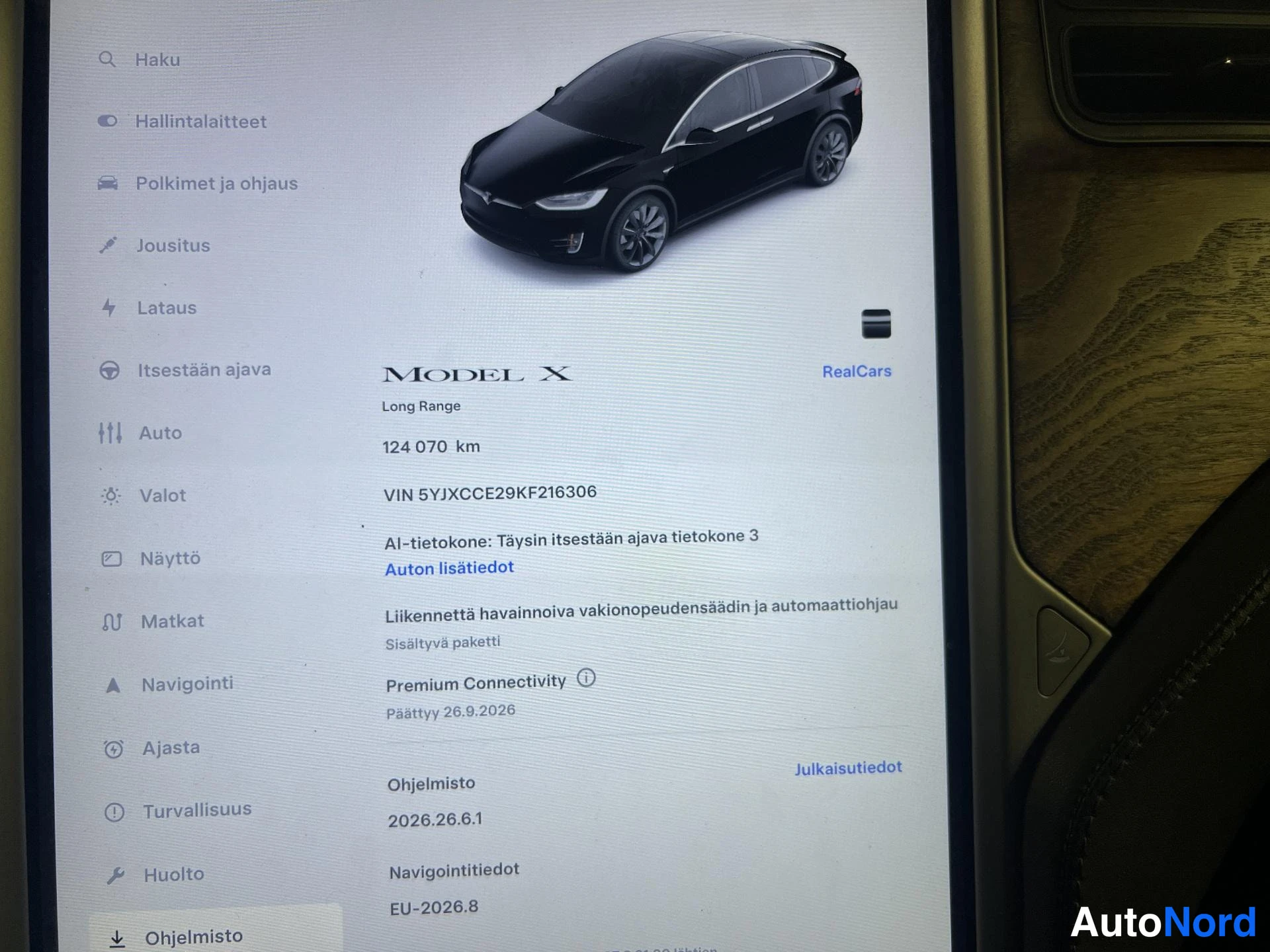 Asiakirja: Auton näytön ohjaamo-näkymä, jossa Model X -kuvake ja tiedot 124 070 km, VIN ja ohjelmistoversio 2026.26.6.1.