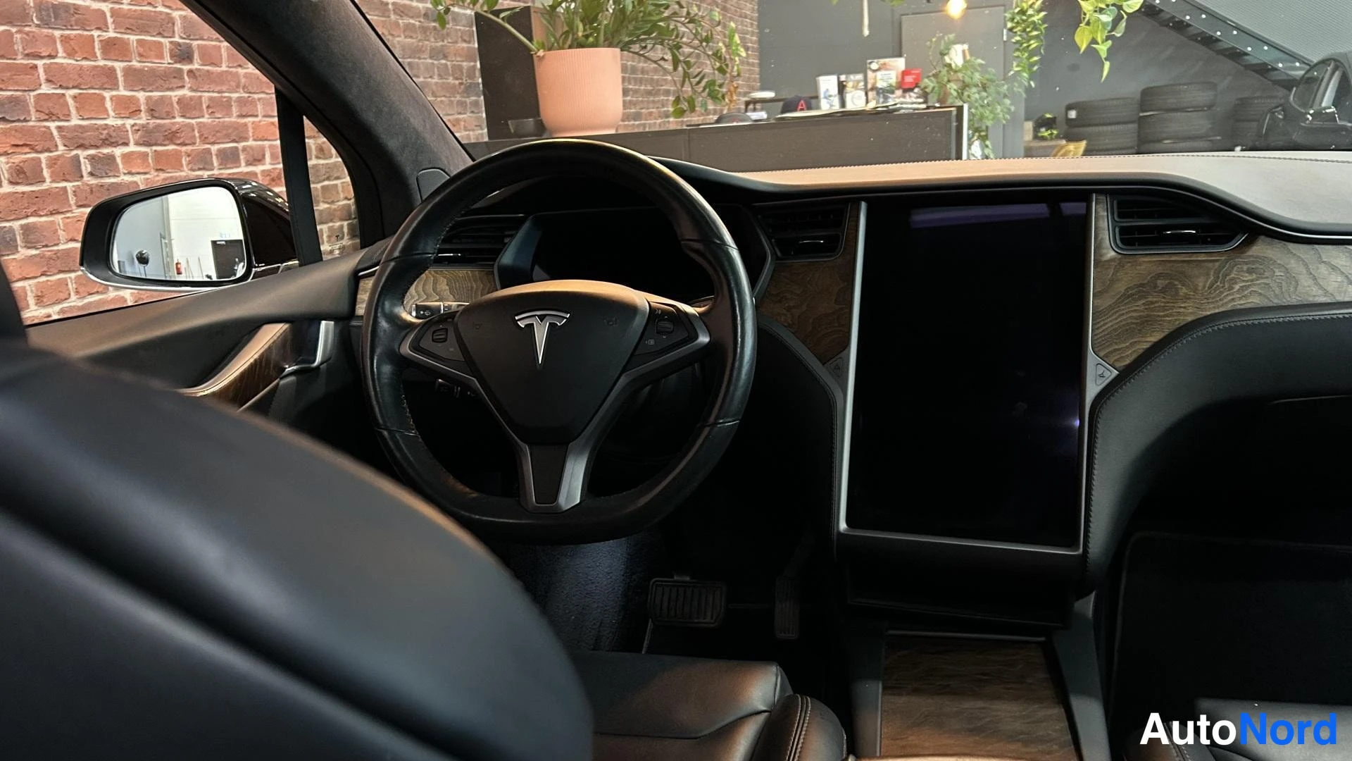 Muu: Tesla-merkillä varustettu ohjauspyörä ja keskikonsolin iso näyttö, tumma ohjaamo.