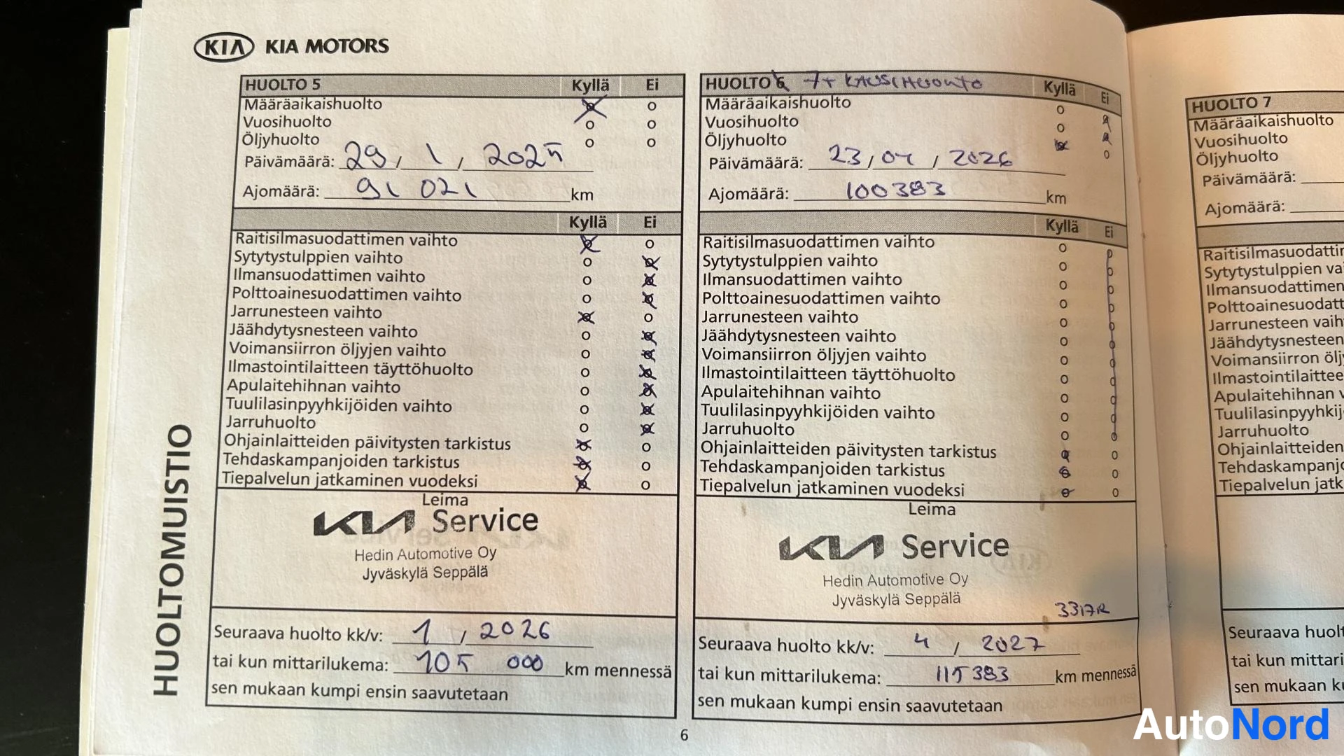 Muu: Auki avattu KIA Motors huoltokirja, jossa näkyvät Huolto 5 ja Huolto 6 -sivut täytettynä.